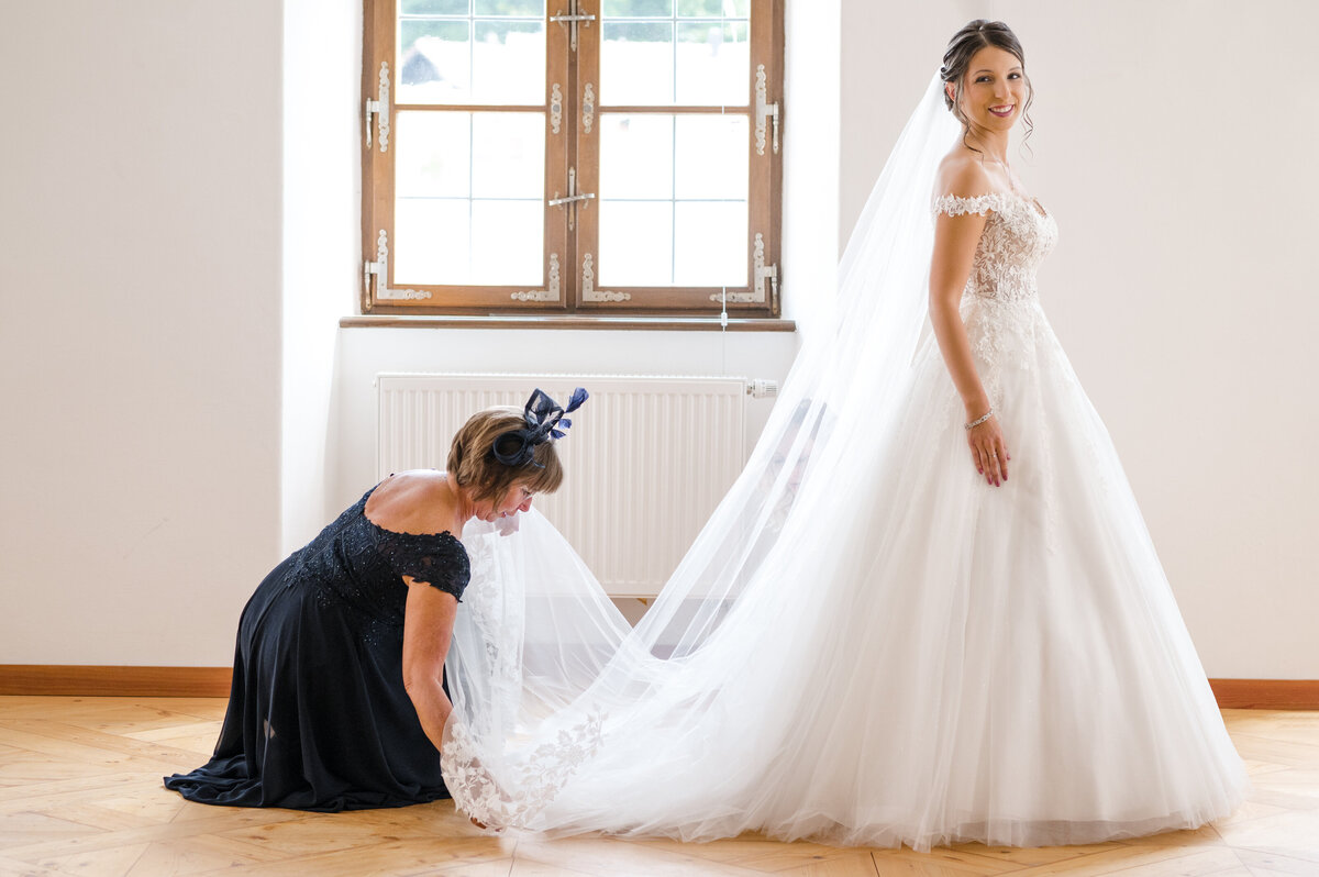 Brautmutter richtet das Brautkleid Hochzeitsfotograf Passau
