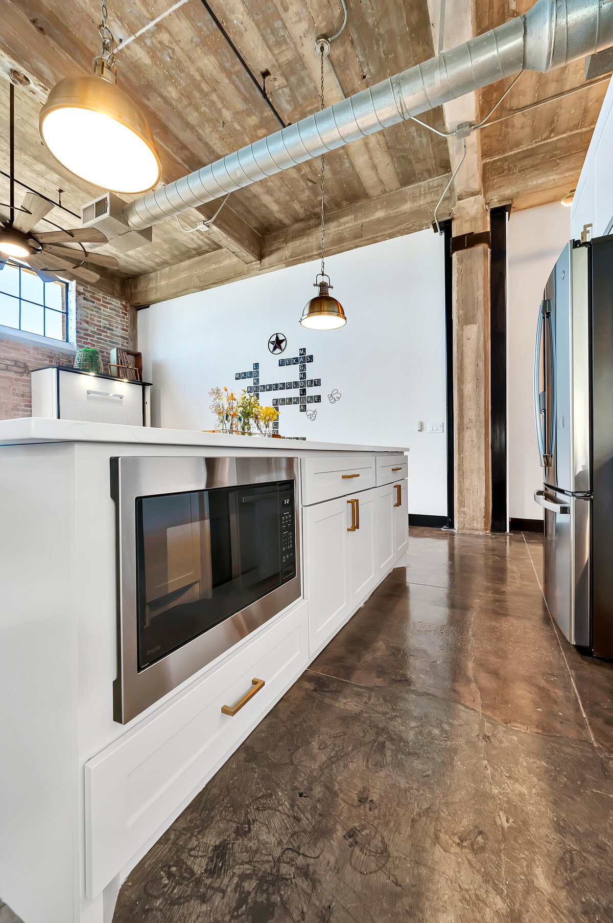 Beautiful kitchen island with view of the living area in this one-bedroom, one-bathroom vintage condo that sleeps 4 in the historic Behrens building in the heart of the Magnolia Silo District in downtown Waco, TX.