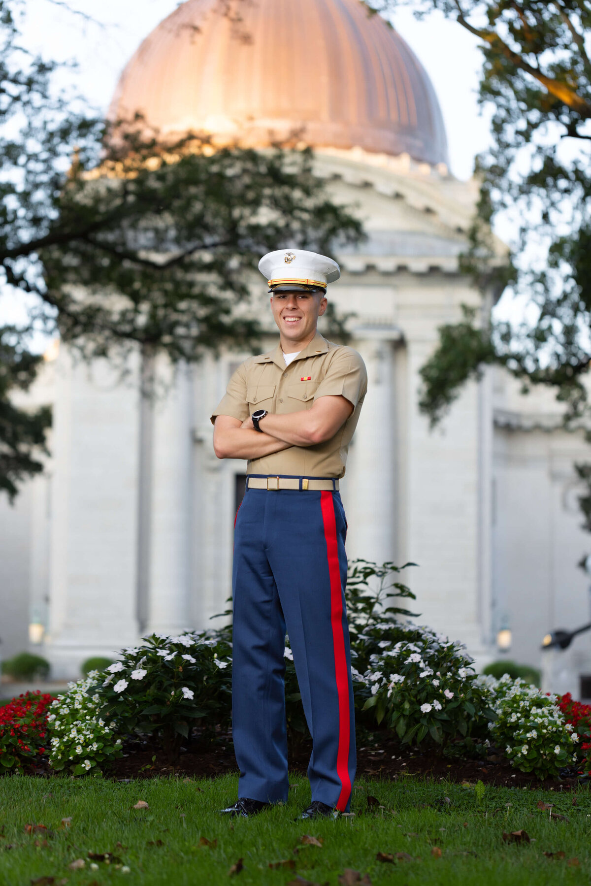 Marine Corps officer in uniform smiles in front of the Naval Academy Chapel dome.
