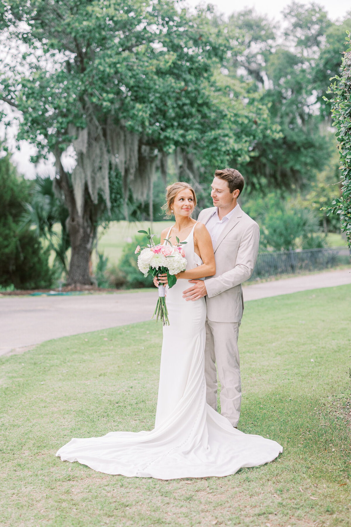 Snuggling bride and groom at their charleston wedding