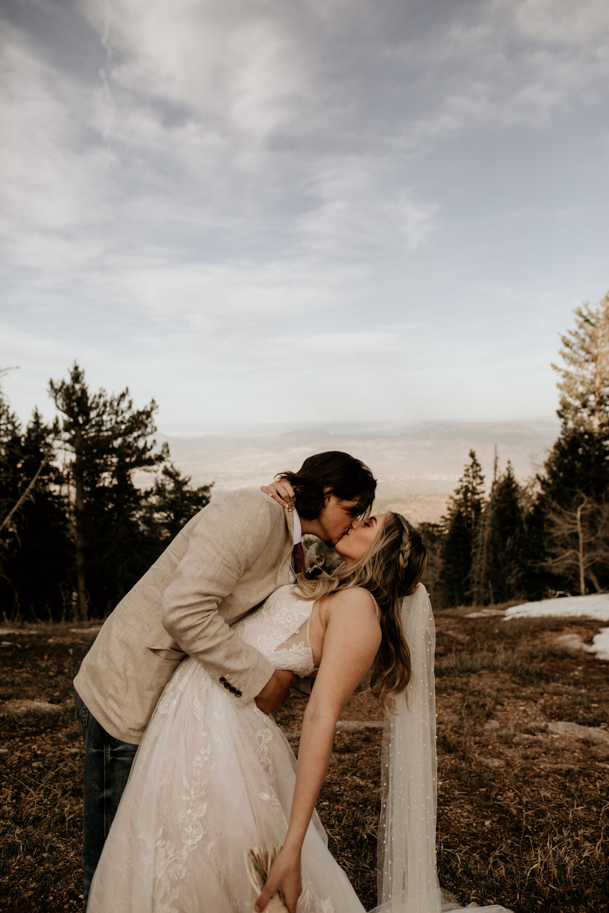 bride and groom kissing on top of the Sandia Mountains