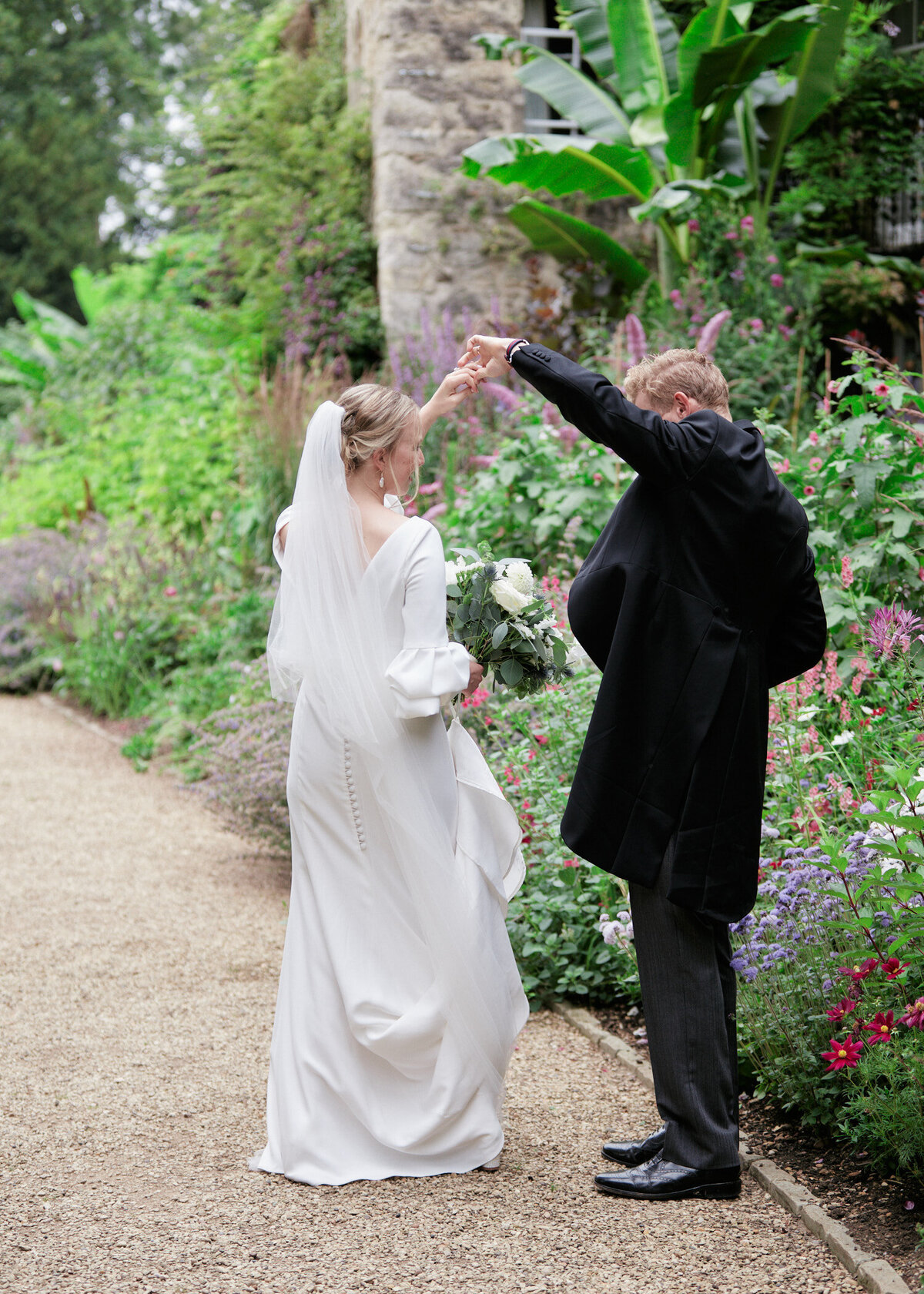 bride and groom dancing at their wedding at Worcester college gardens surrounded by greenery and garden flowers