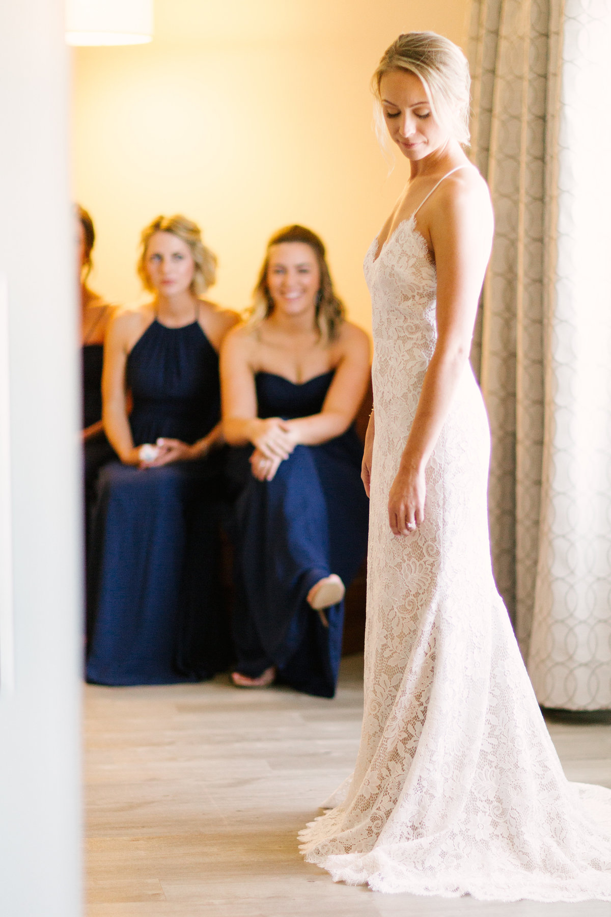 Bridesmaids look at bride as she gets ready for her wedding at Firestone Vineyard