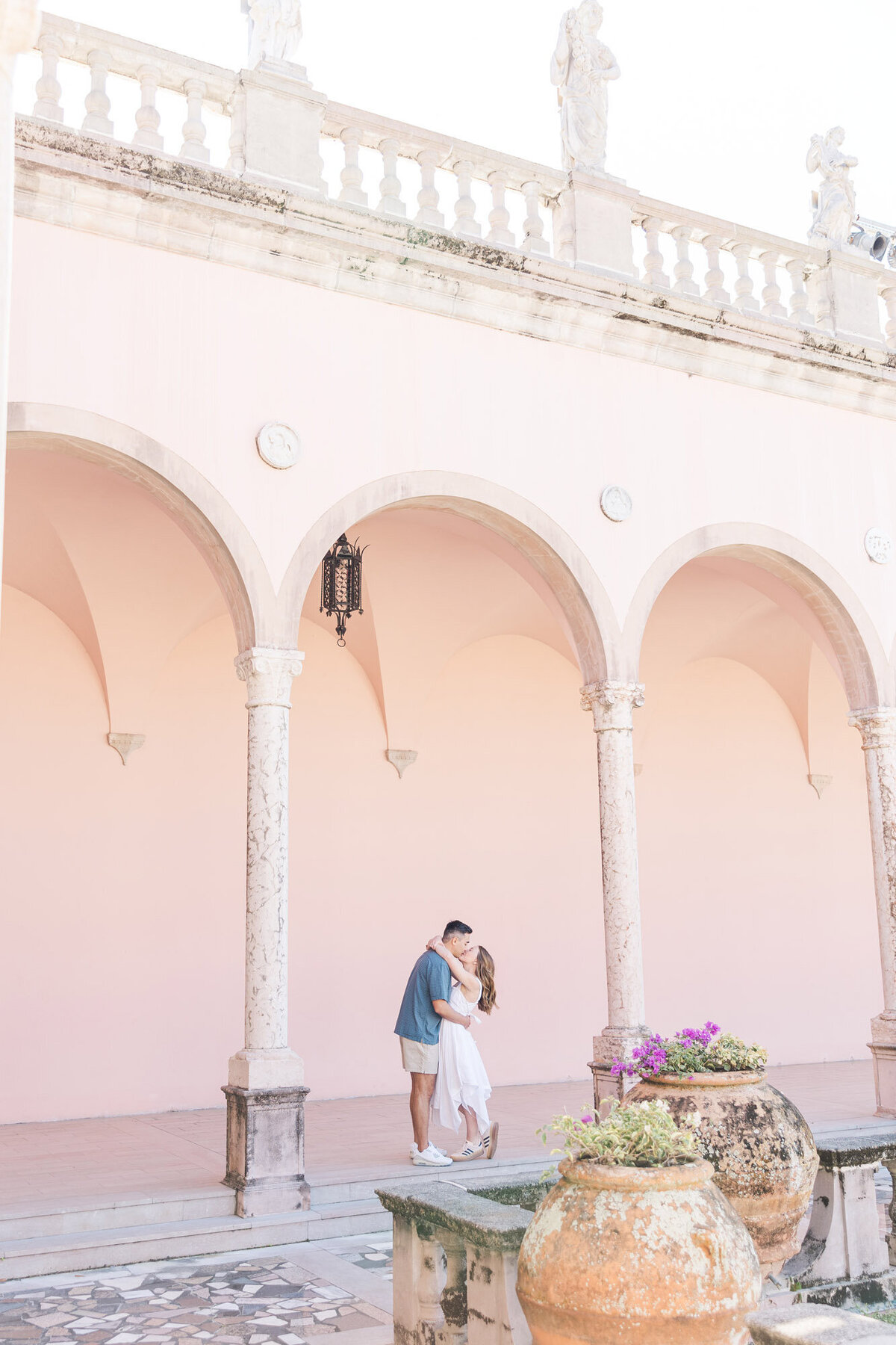 engaged couple kissing under an archway