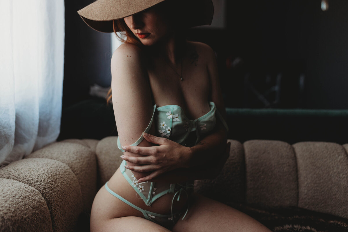 woman hugging herself with lingerie straps hanging down