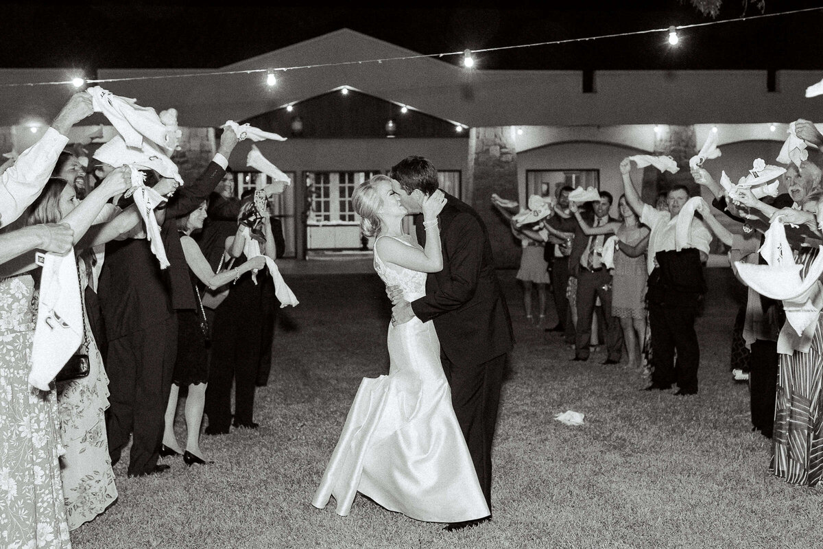 Bride and groom kiss at wedding send off in Texas hill country