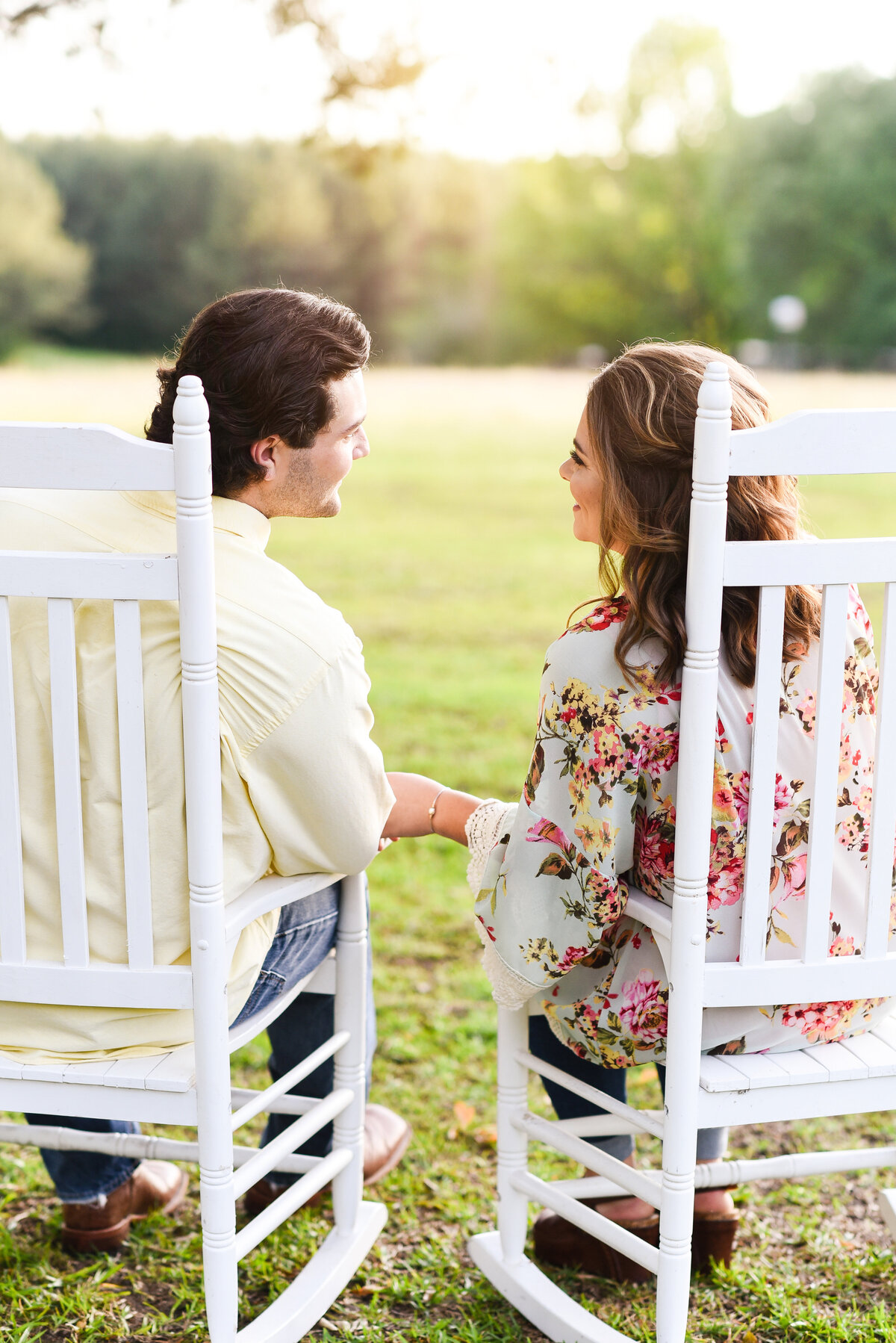 Beautiful Mississippi Engagement Photography: couple holding hands watches sunset from rocking chairs in Mississippi