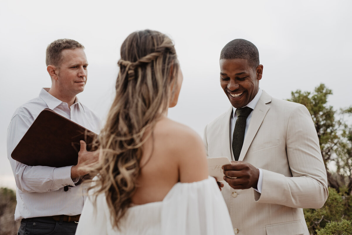 Utah Elopement Photographer captures groom smiling at reading vows