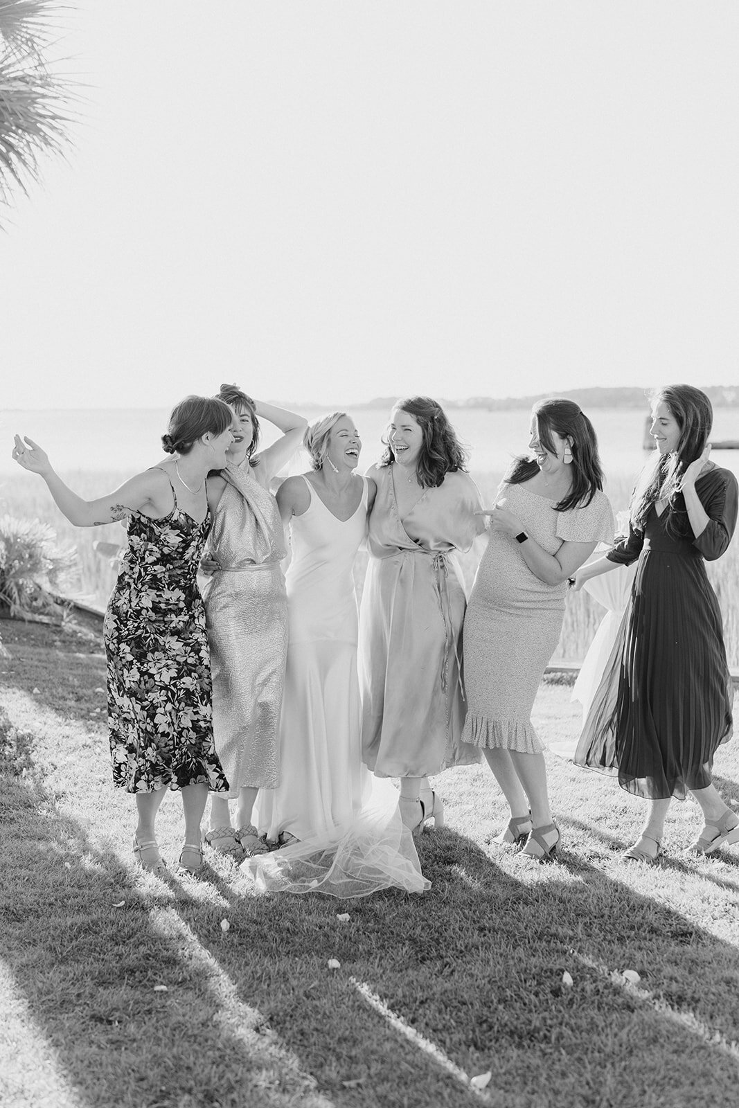 Cocktail hour at waterfront wedding in Charleston. Bride gets a picture with her best friends on her wedding day. Kailee DiMeglio Photography. Candid wedding photos.
