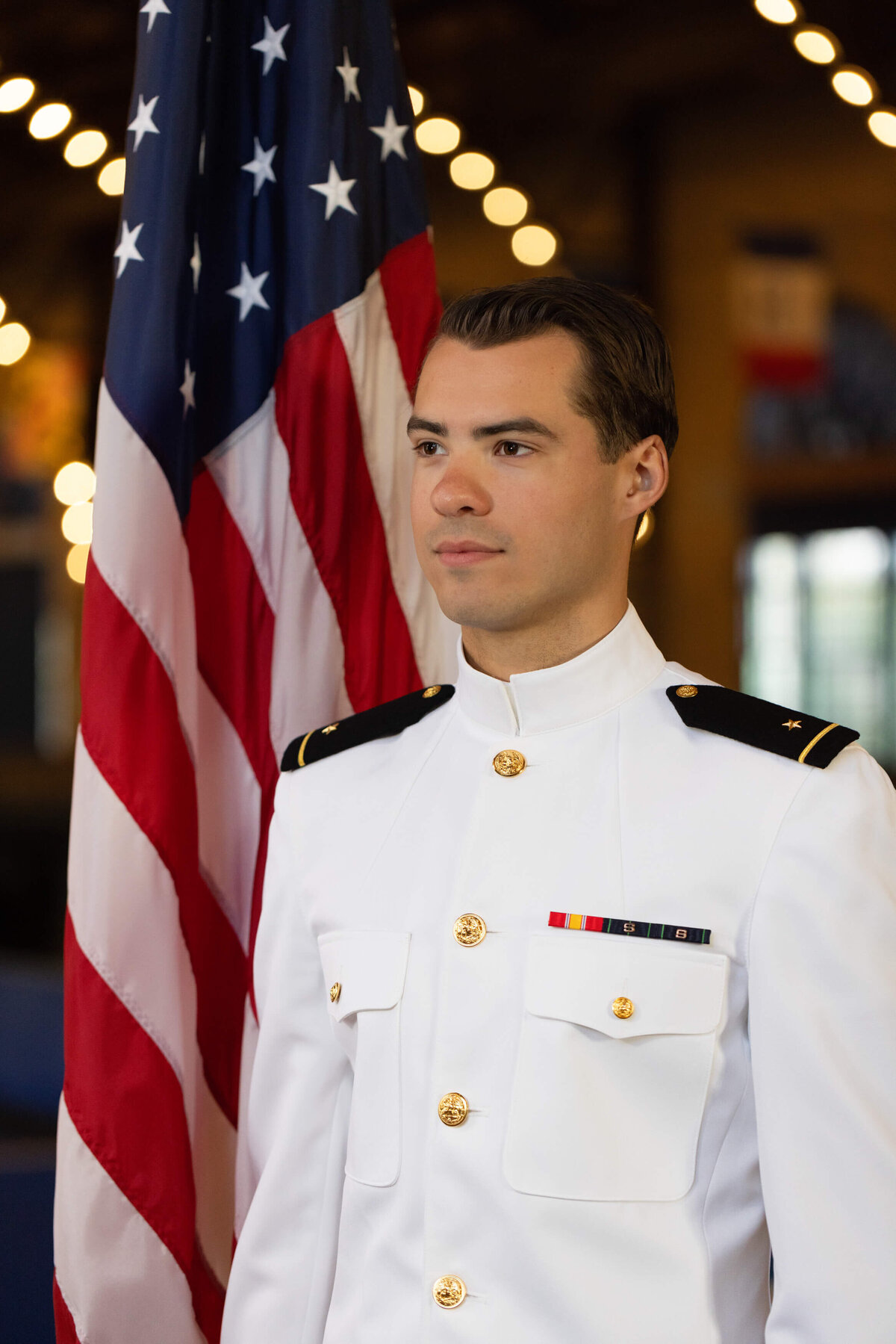 USNA Midshipman senior portrait in Dahlgren Hall with American flag at US Naval Academy.