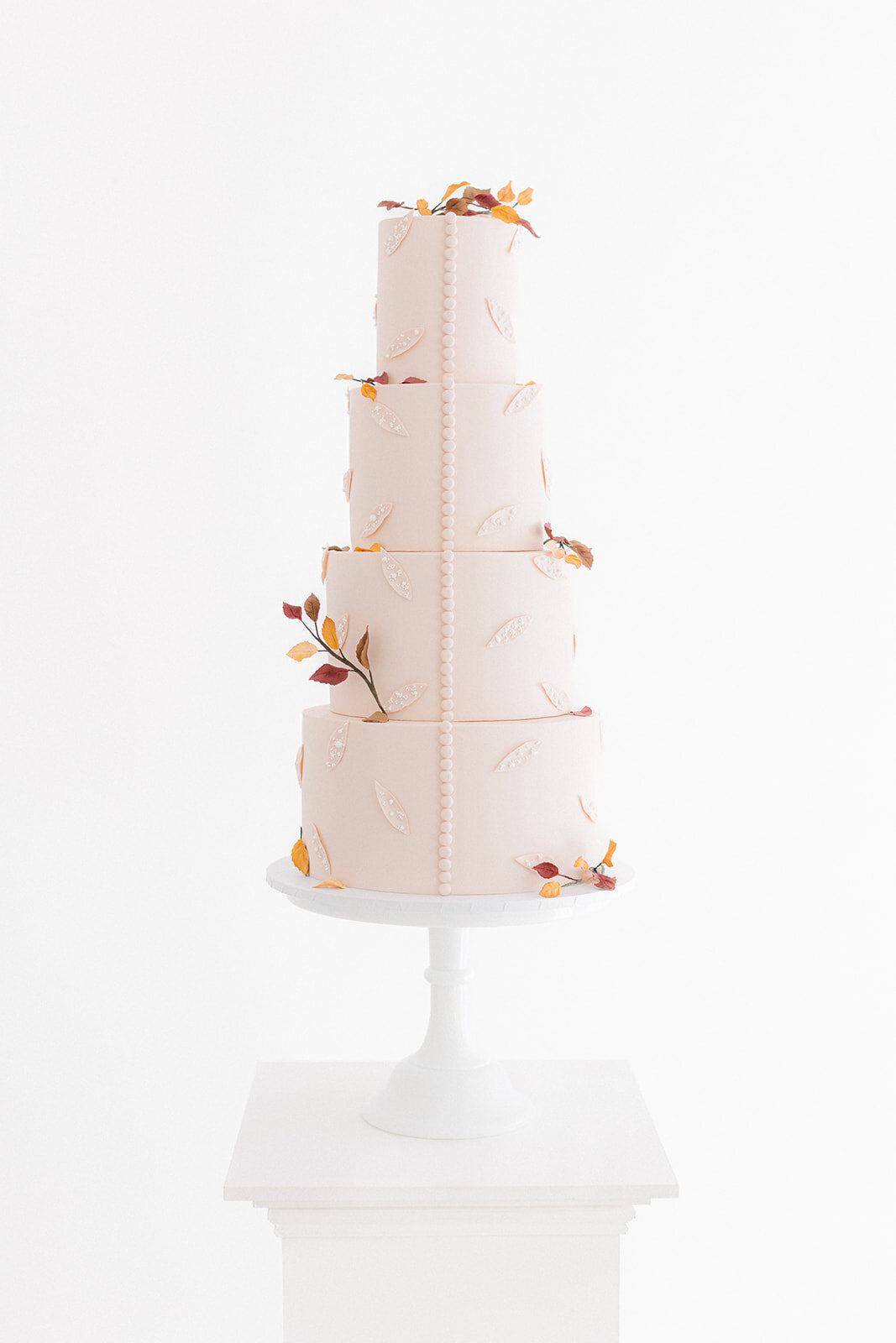 Autumn inspired wedding cake with autumn leaves, beading and buttons