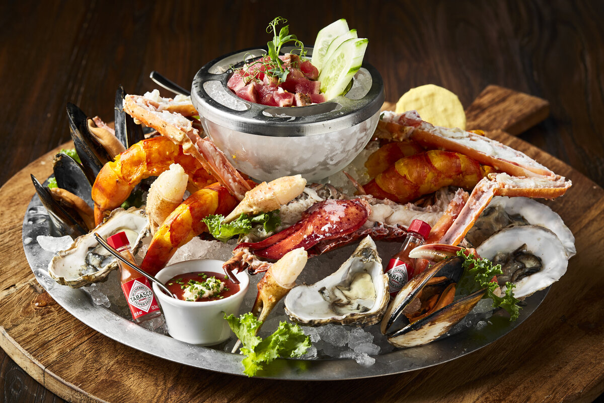 Seafood platter on ice with crabs, prawns, mussels,, oysters and raw tuna.