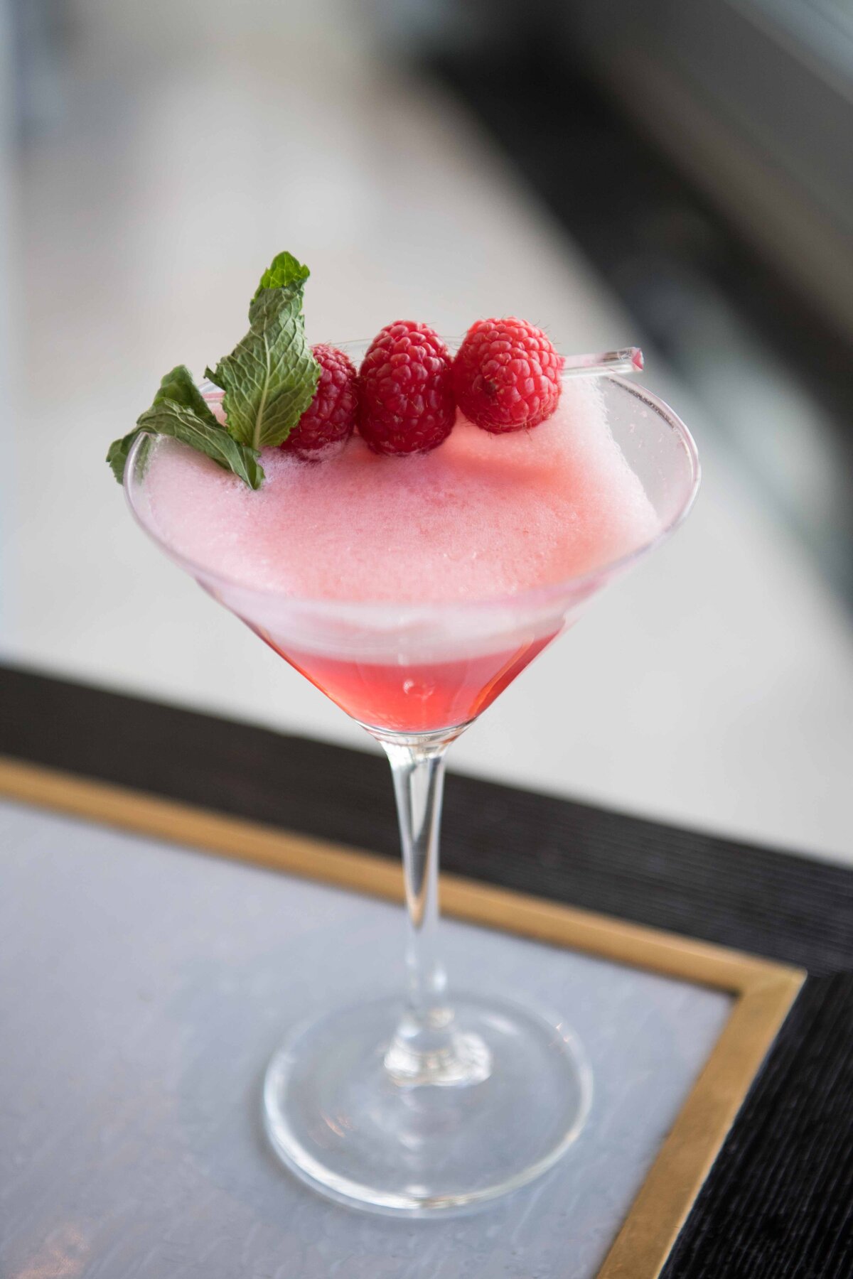 A Martini with raspberries and mint and mint