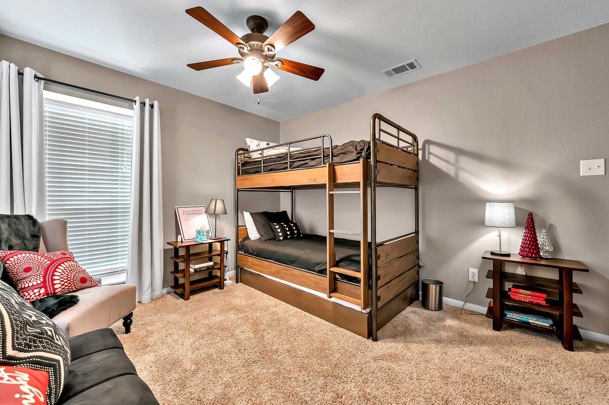 Bedroom with bunk beds in this four-bedroom, four-bathroom vacation rental home and guest house with free WiFi, fully equipped kitchen, firepit and room for 10 in Waco, TX.