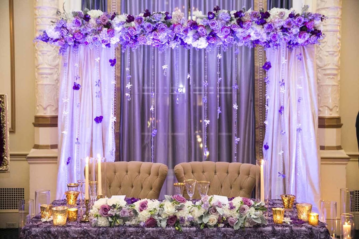 The head table was framed by a beautiful purple floral arch and strands of purple orchids.