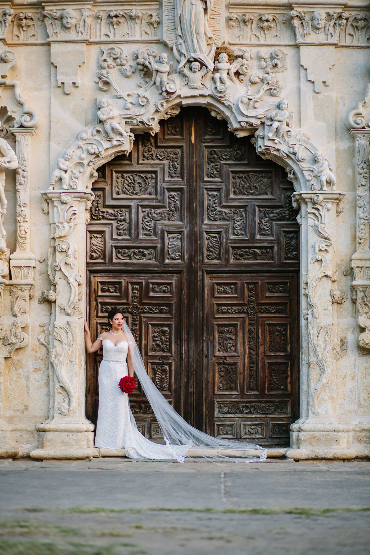bride in front of mission San Jose door in San Antonio