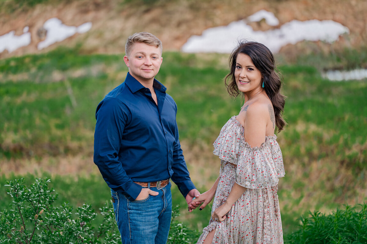 A couple standing on the mountain side for their engagement photos enjoying their Raleigh wedding photography