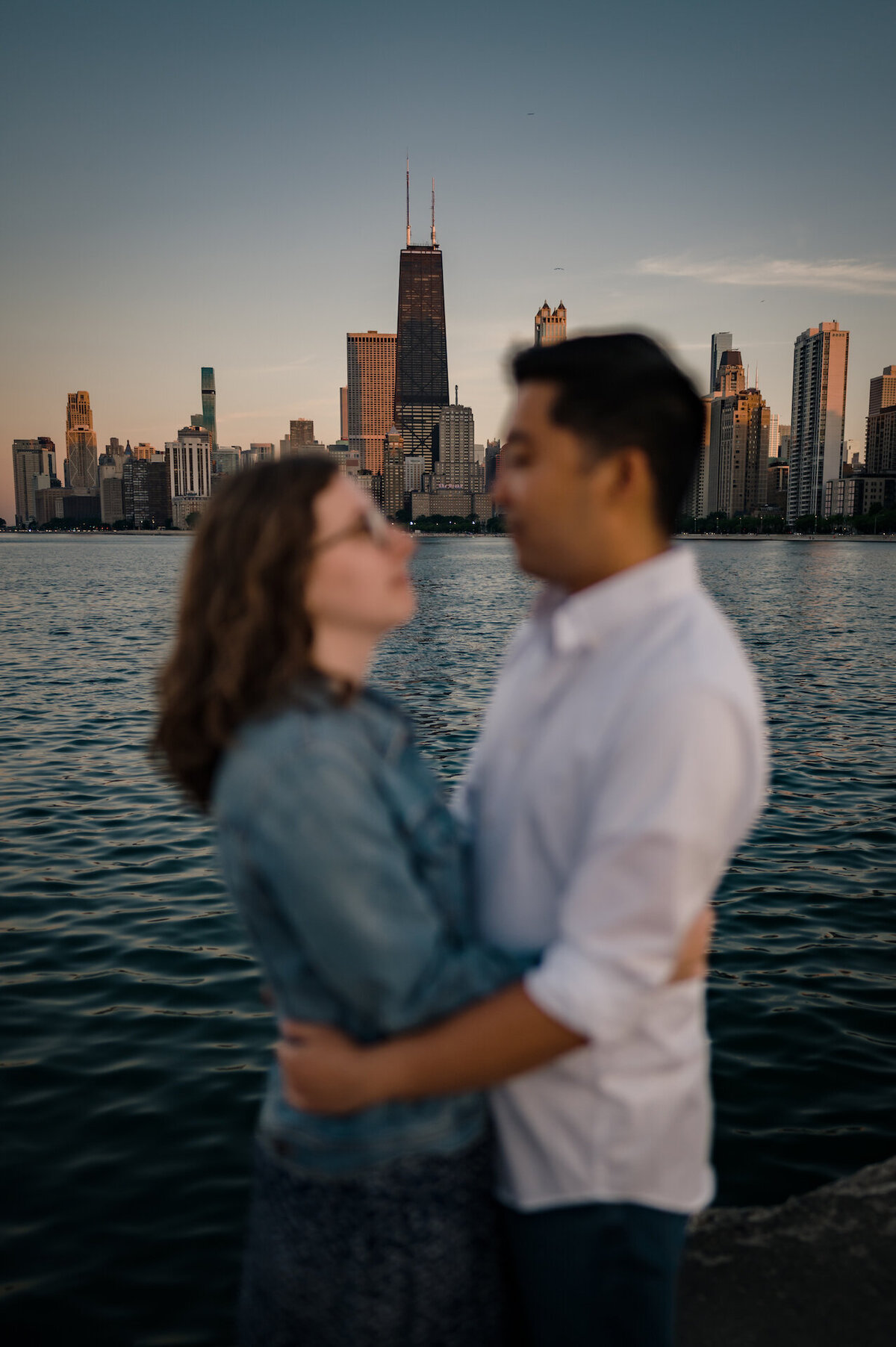 A couple embrace in front of the Chicago skyline