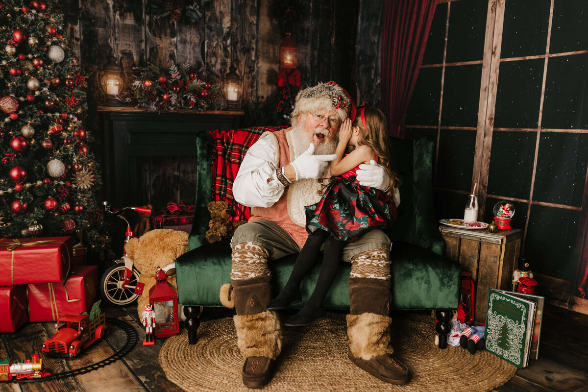 Telling Santa Claus a secret on his lap in Seattle Studio