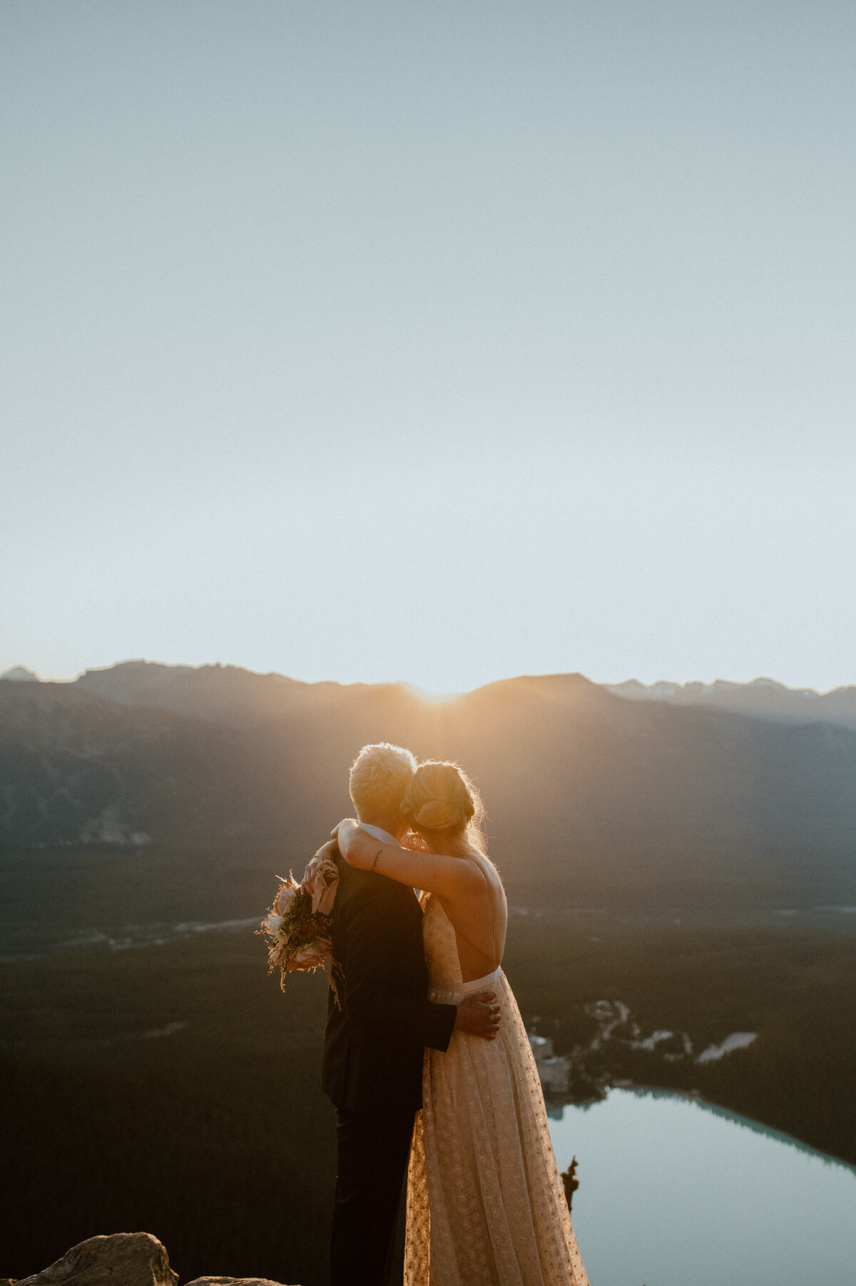wedding couple on top of mountain at sunrise