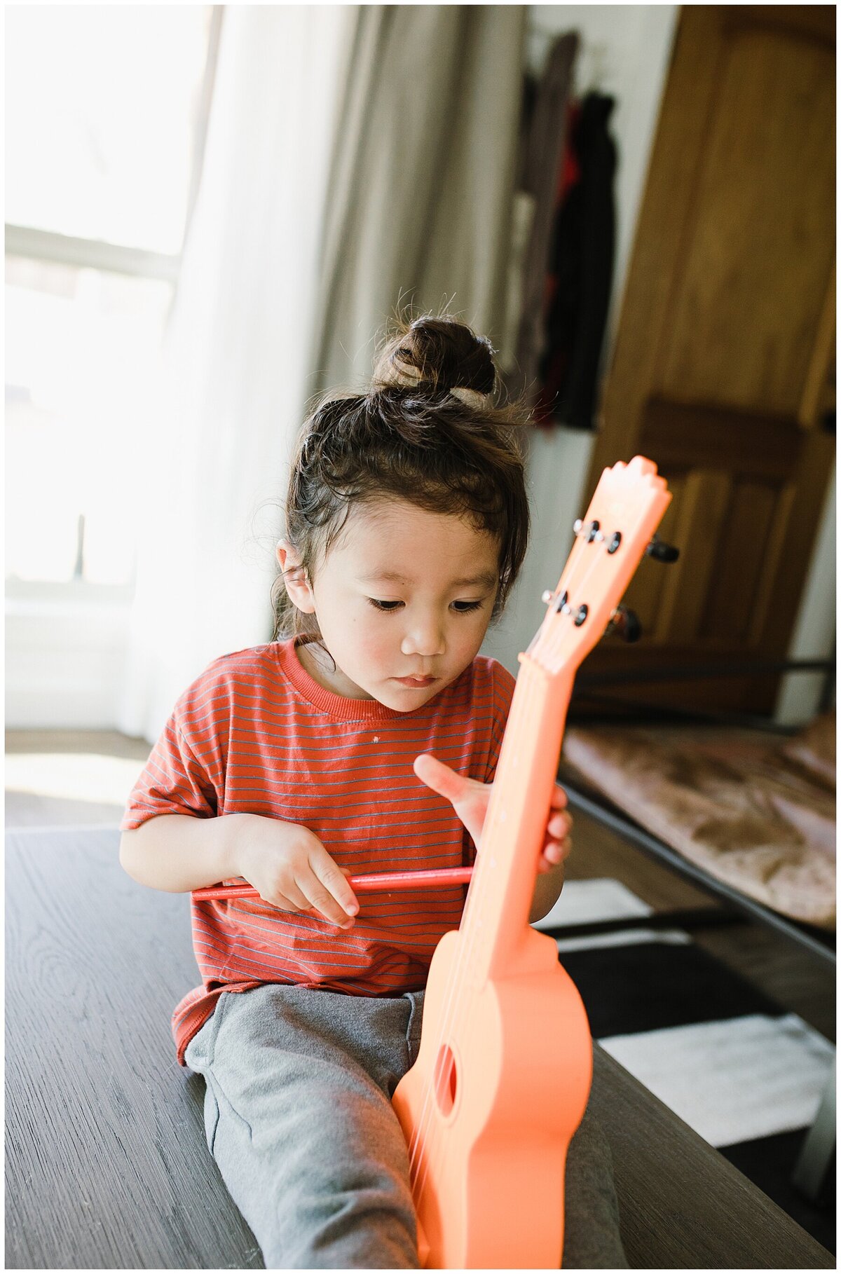 Boy with orange guitar at family photo session in Austin by Amber Vickey Photography