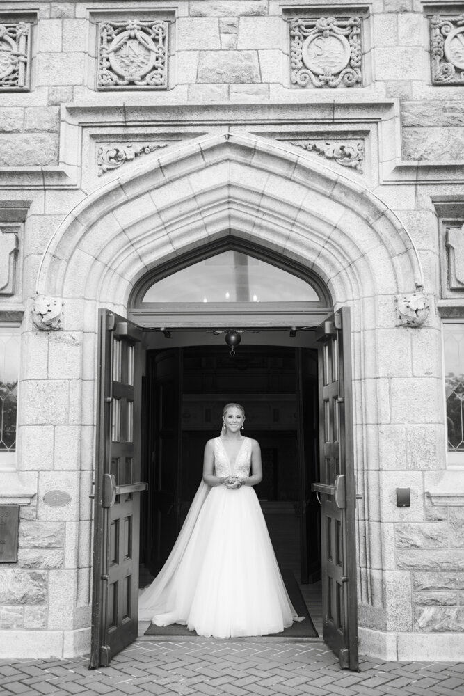 bride standing in doorway of beautiful church - gold shoes and wedding details - branford house wedding