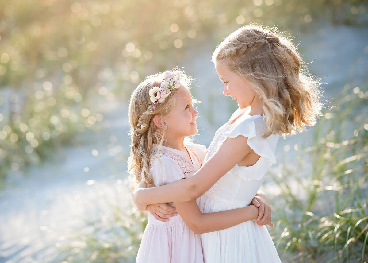 Family session of two little girls outside hugging