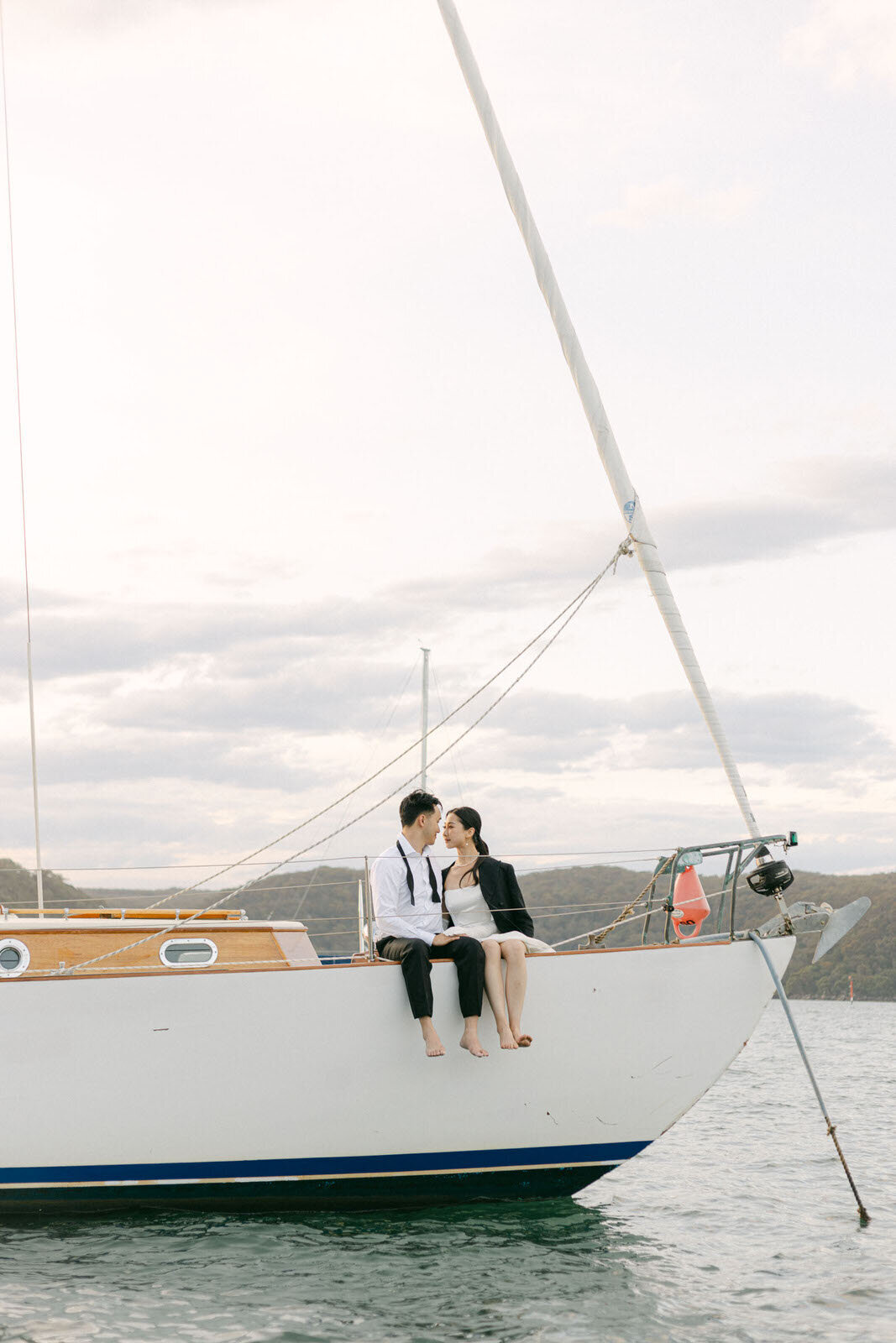 engaged couple sitting on a sailboat