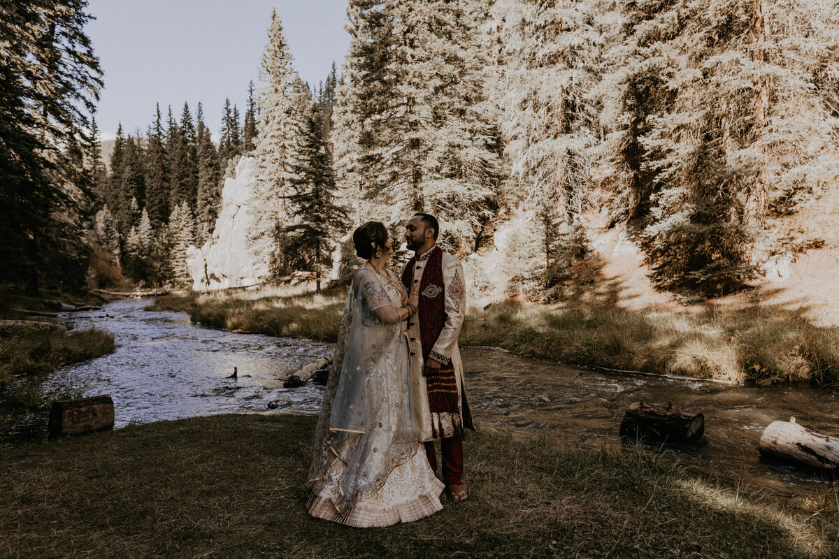 bride and groom exchanging vows in front of a creek