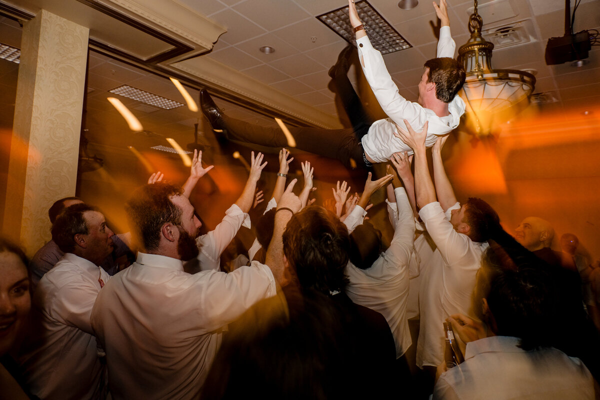 groom being lifted on dance floor light shutter drag effect