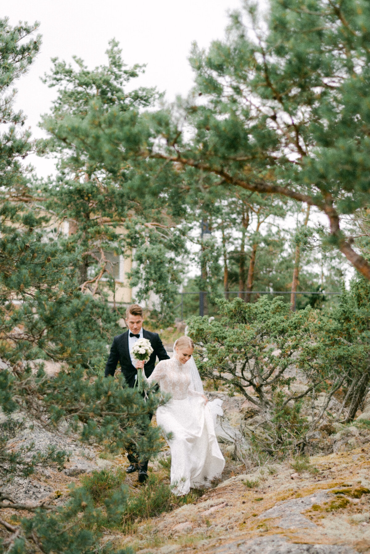 A wedding couple walking in the forest in Finland during a photoshoot with wedding photographer Hannika Gabrielsson.