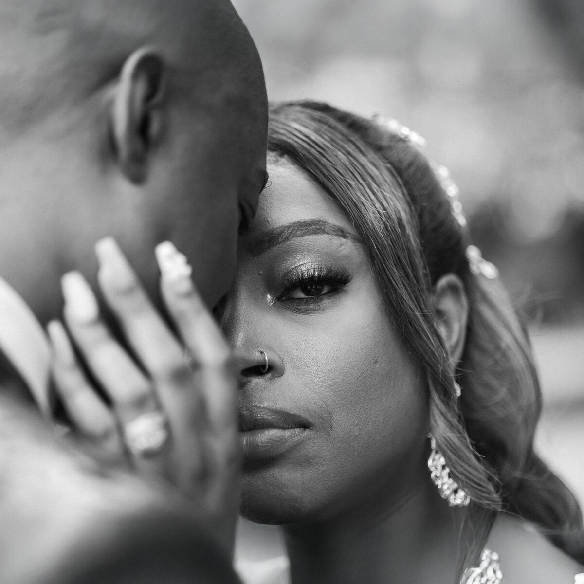 Intimate black and white close-up bridal portrait of a couple sharing a tender moment during their wedding at pristine chapel