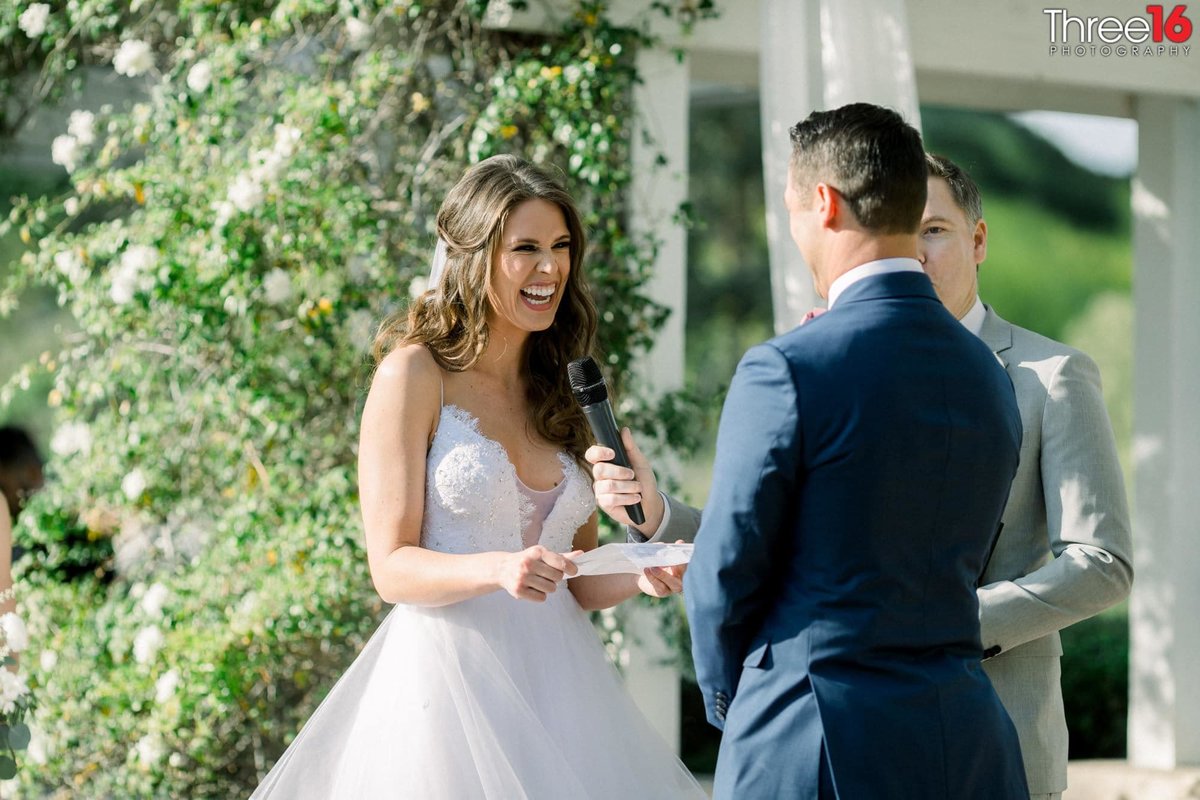 Bride laughs as she says her vows to her Groom