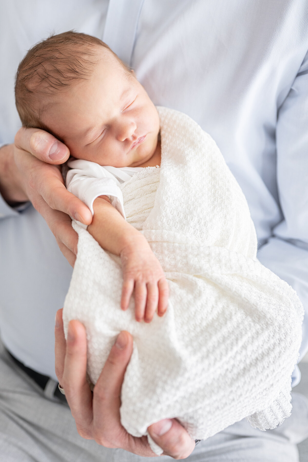 A father holding his newborn baby to his chest
