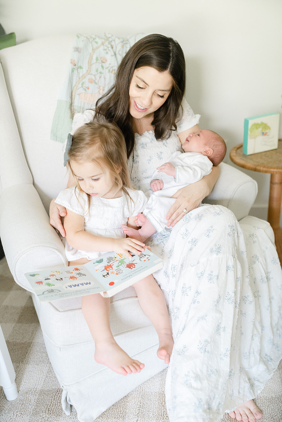 a mother and daughter reading stories to newborn baby