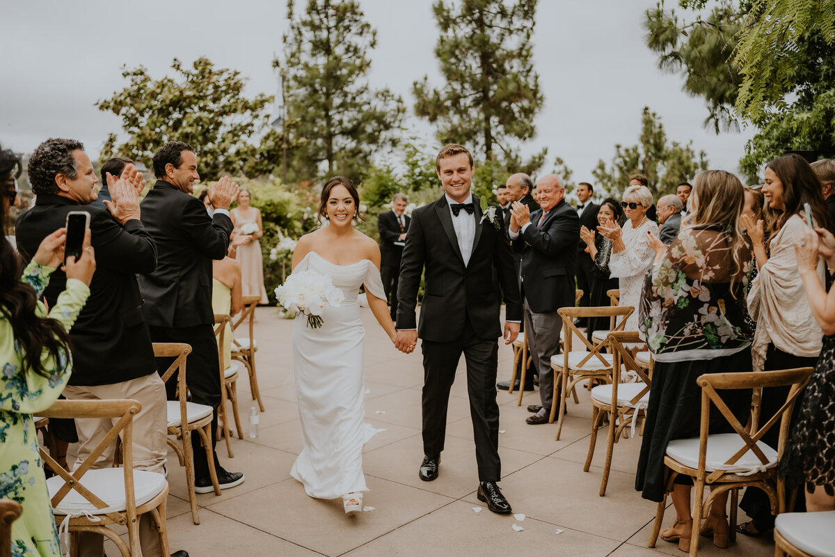 Man and woman walking down isle after wedding