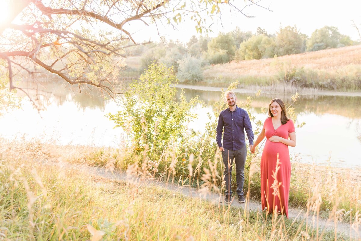 Husband and wife hold hands during maternity session  Colorado