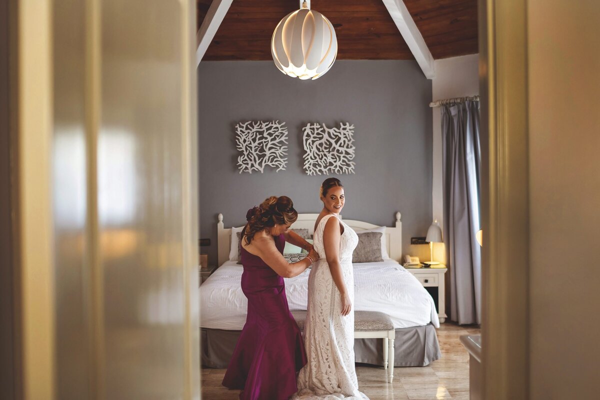 Mother helping bride into dress in room at Grand Palladium Colonial Resort, Riviera Maya wedding