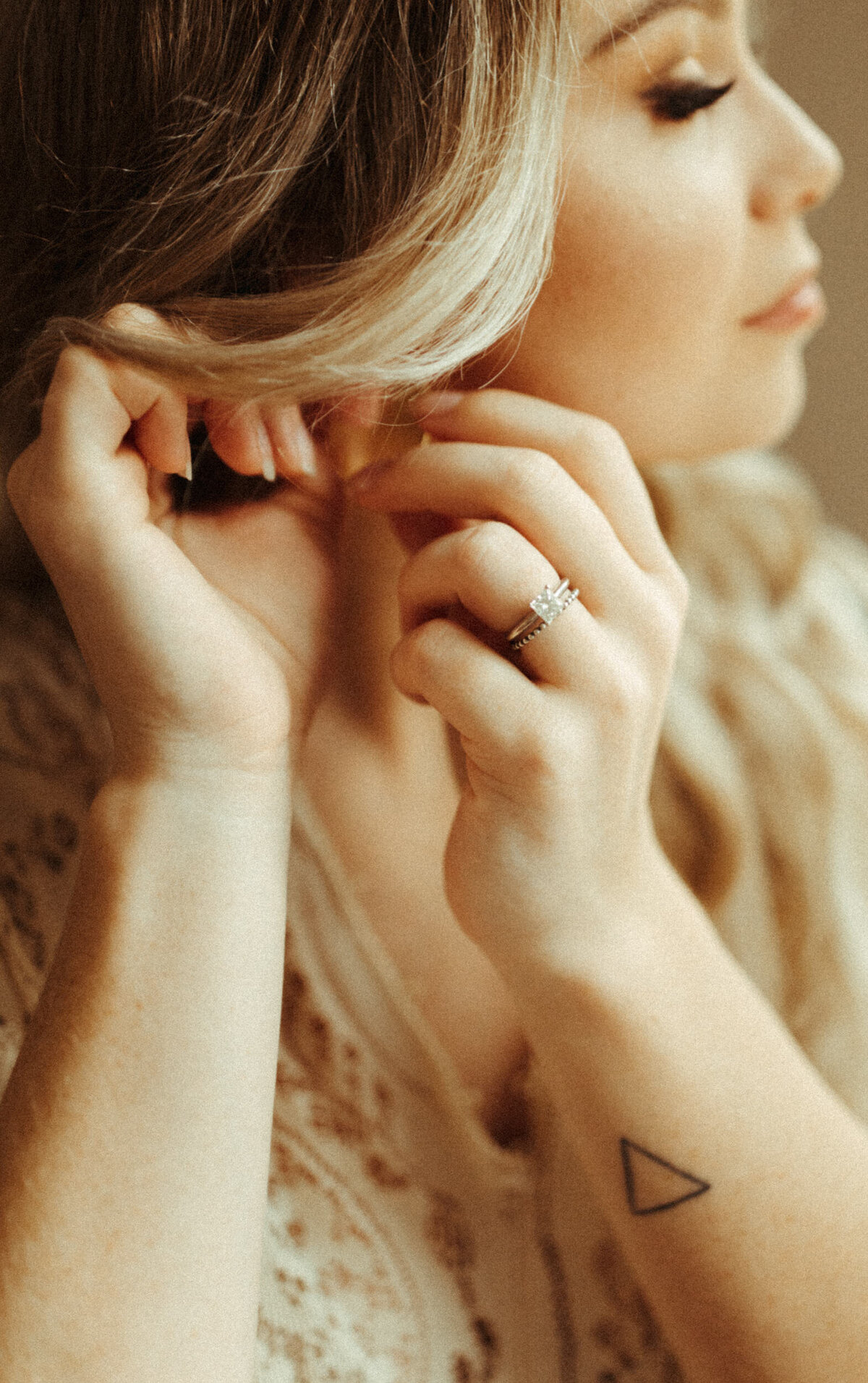 Close up of the bride putting her earrings in and getting ready for elopement day