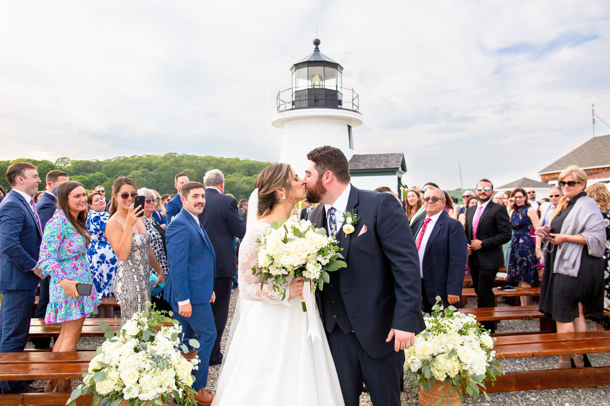 Bride and groom kiss as they walk down the aisle after their wedding ceremony at the Mystic Seaport.