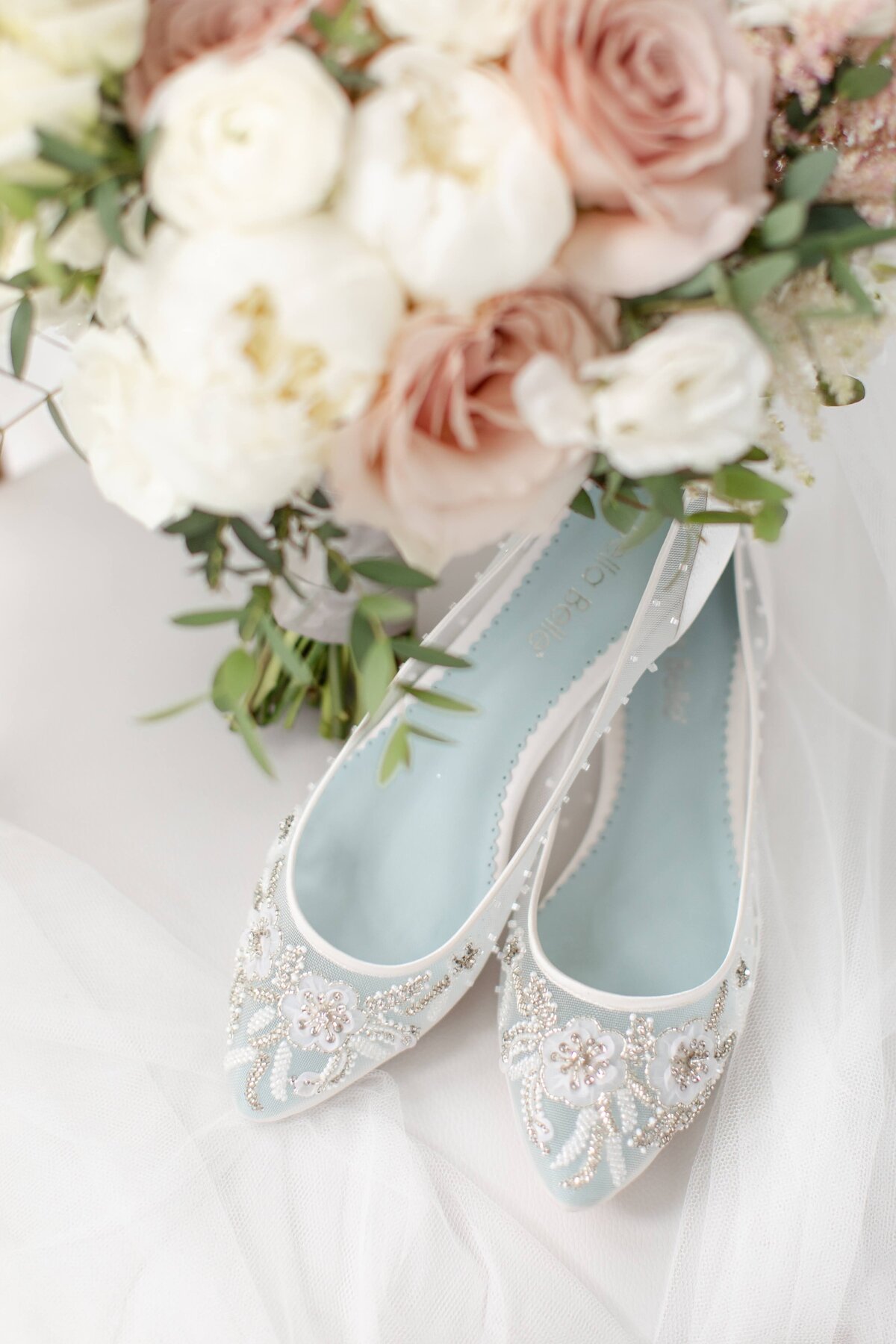 blush and white flowers with bridal shoes
