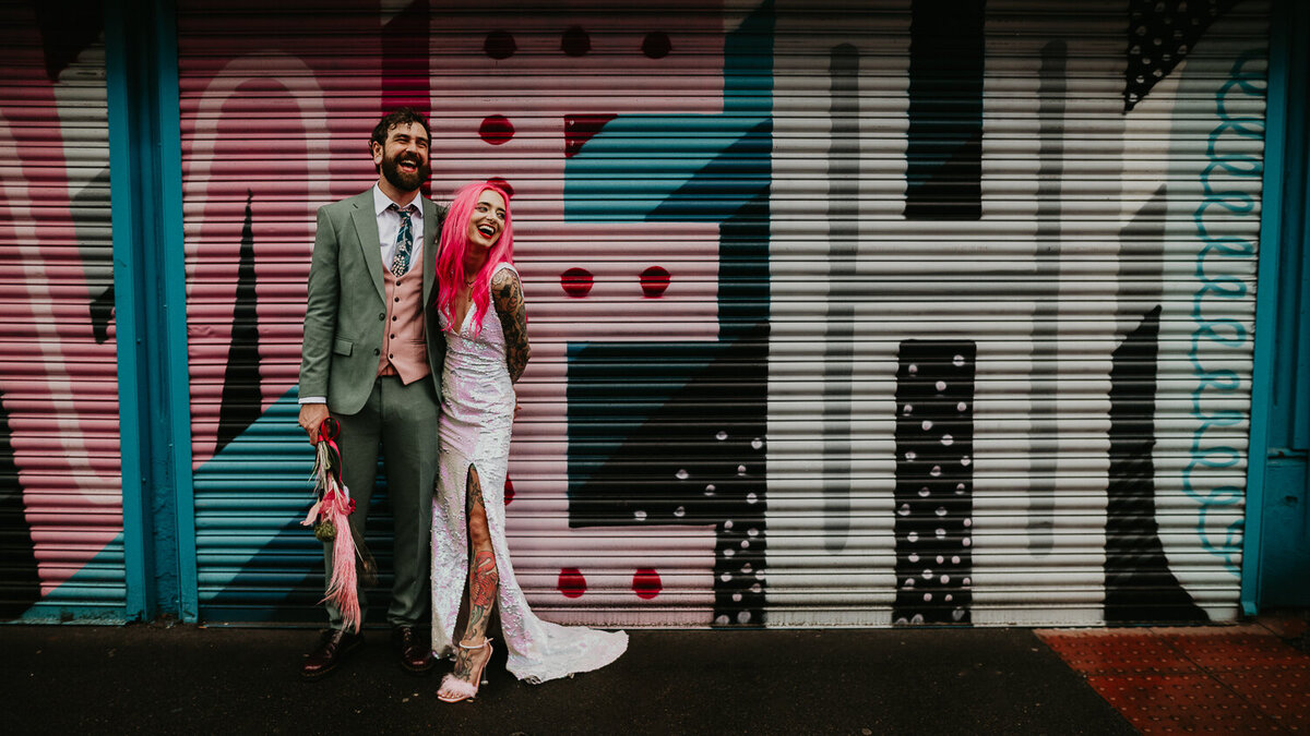 Alternative wedding couple stand outside a Manchester Coffee shop in the Northern Quarter.