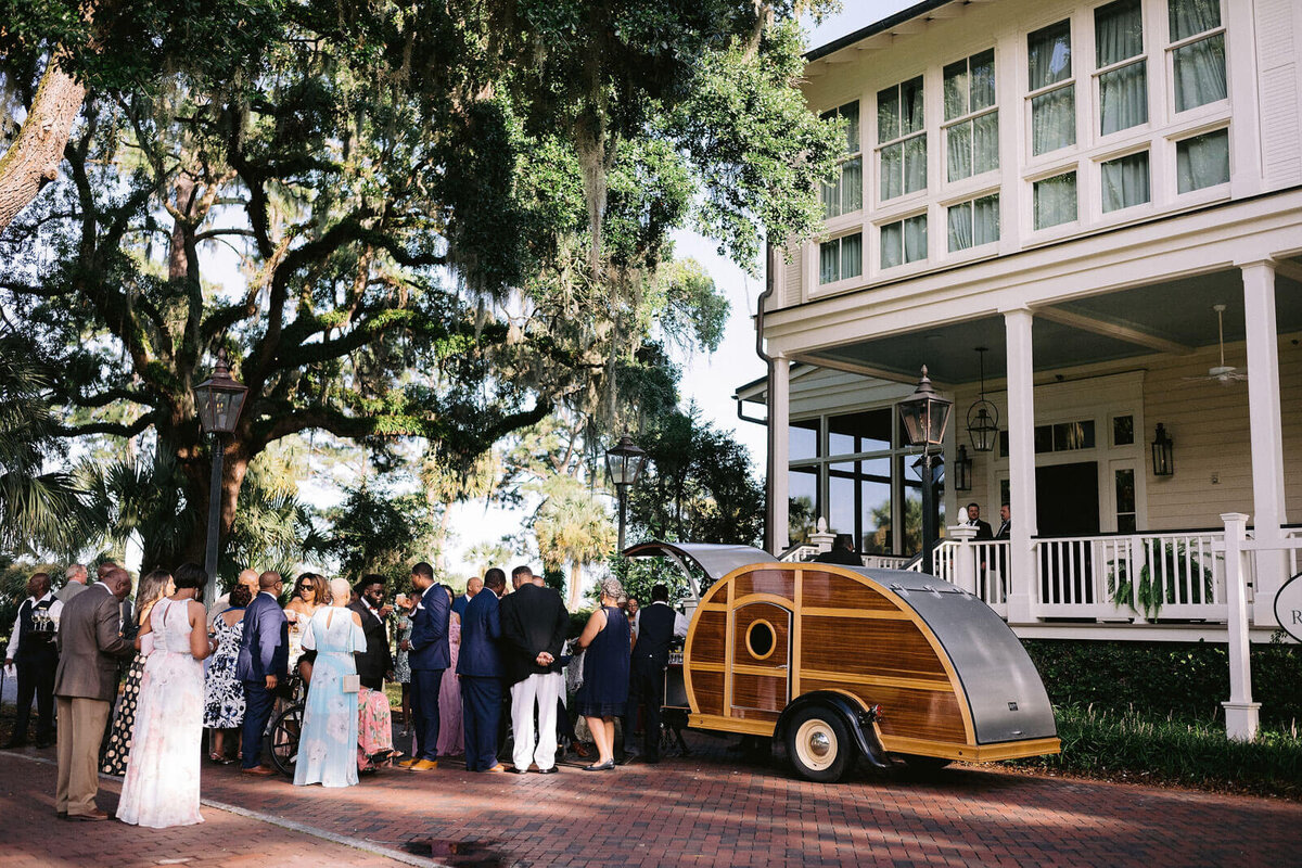 The guests are drinking outside in the mobile bar in Montage at Palmetto Bluff. Destination wedding image by Jenny Fu Studio