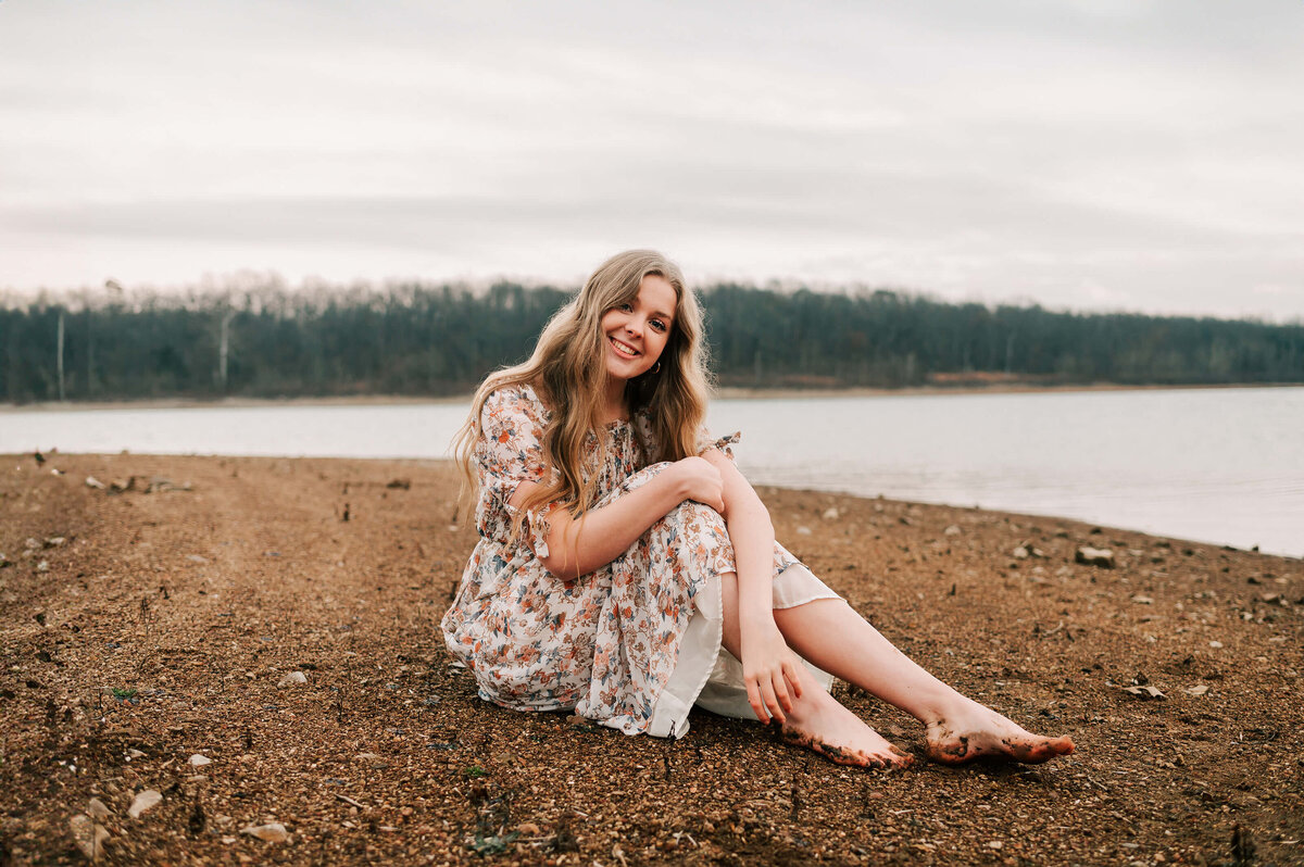 Springfield MO senior photographer Jessica Kennedy of The XO Photogrpahy captures teen girl sitting in sand near the lake