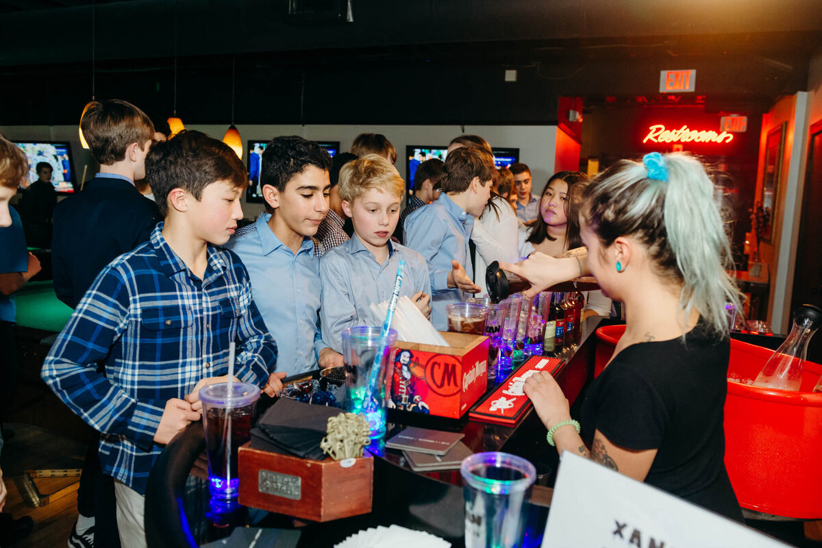 A group of boys order sodas from the bar at a bar mitzvah