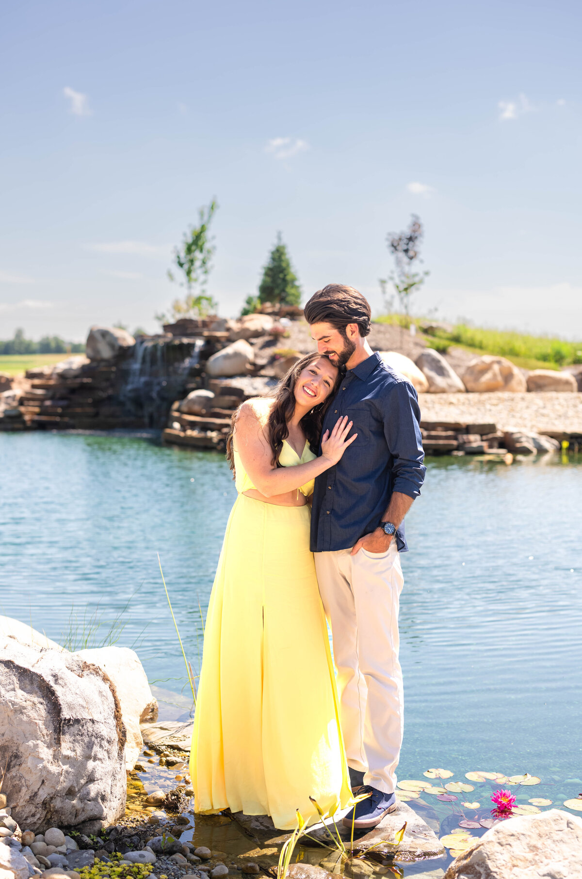 Engaged couple standing near lake