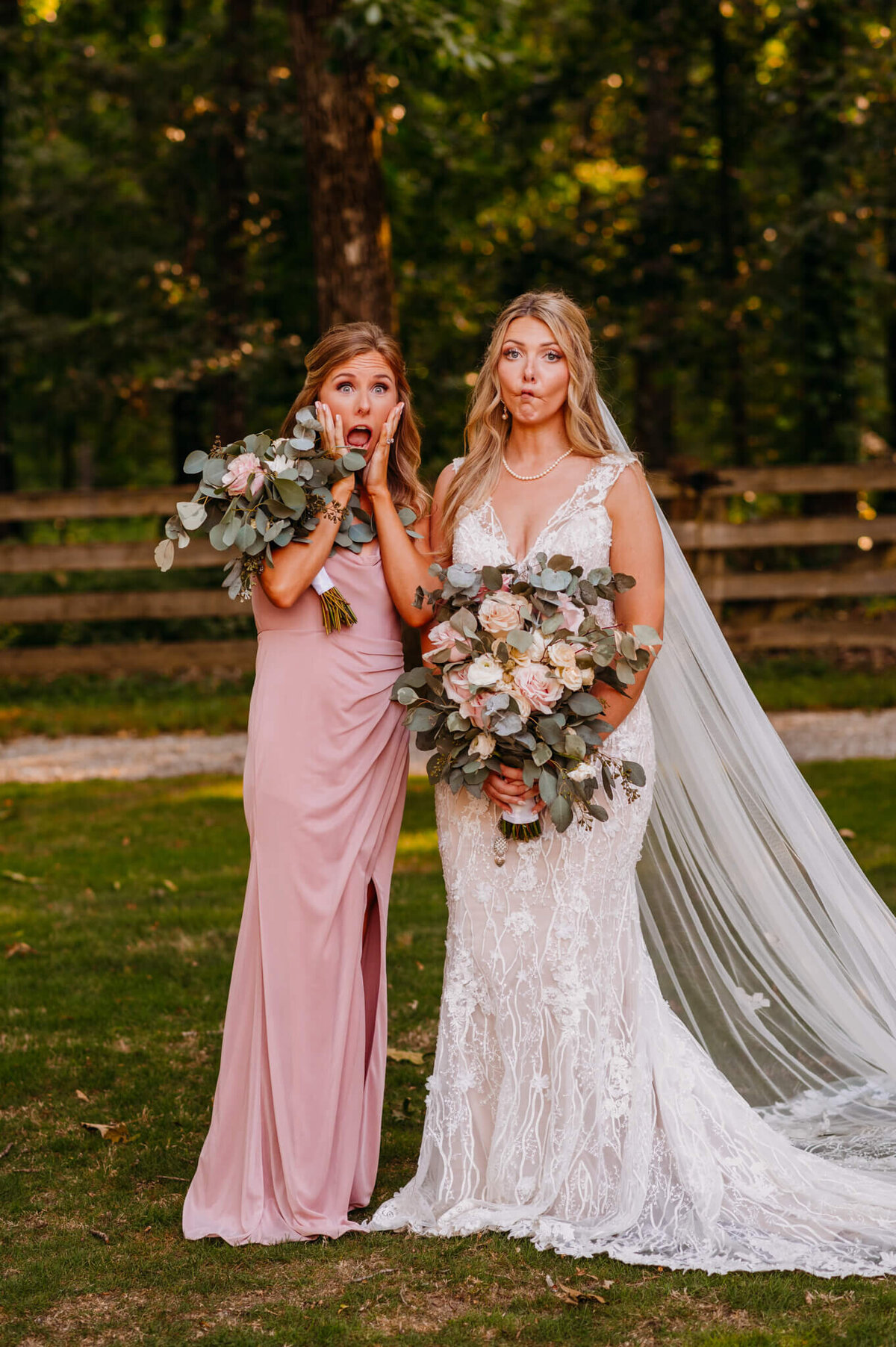 Photo of a woman in a pink dress and a bride making silly faces and holding bouquets