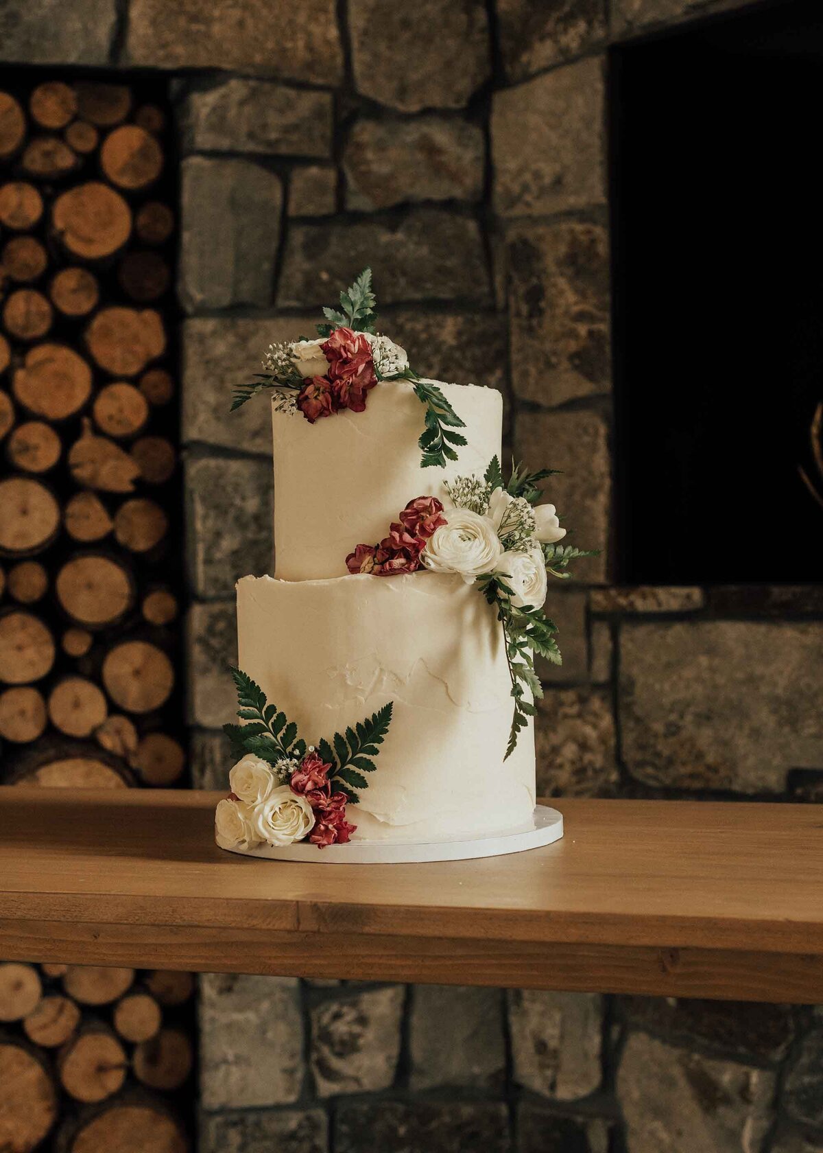 Maddie Rae Photography two tiered wedding cake that has flowers on it