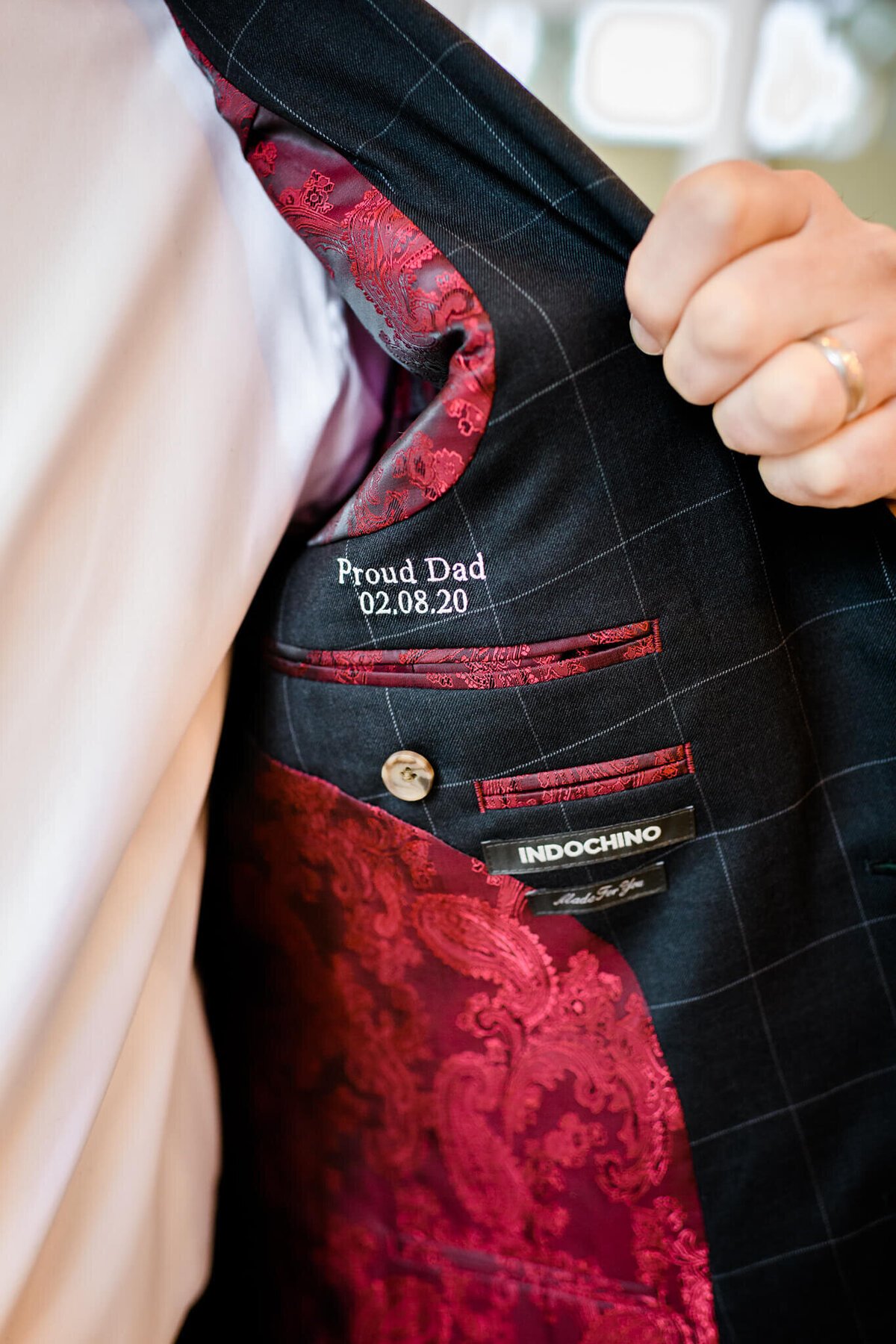 A father shows off his embroidered suit pocket commemorating his sons bar mitzvah