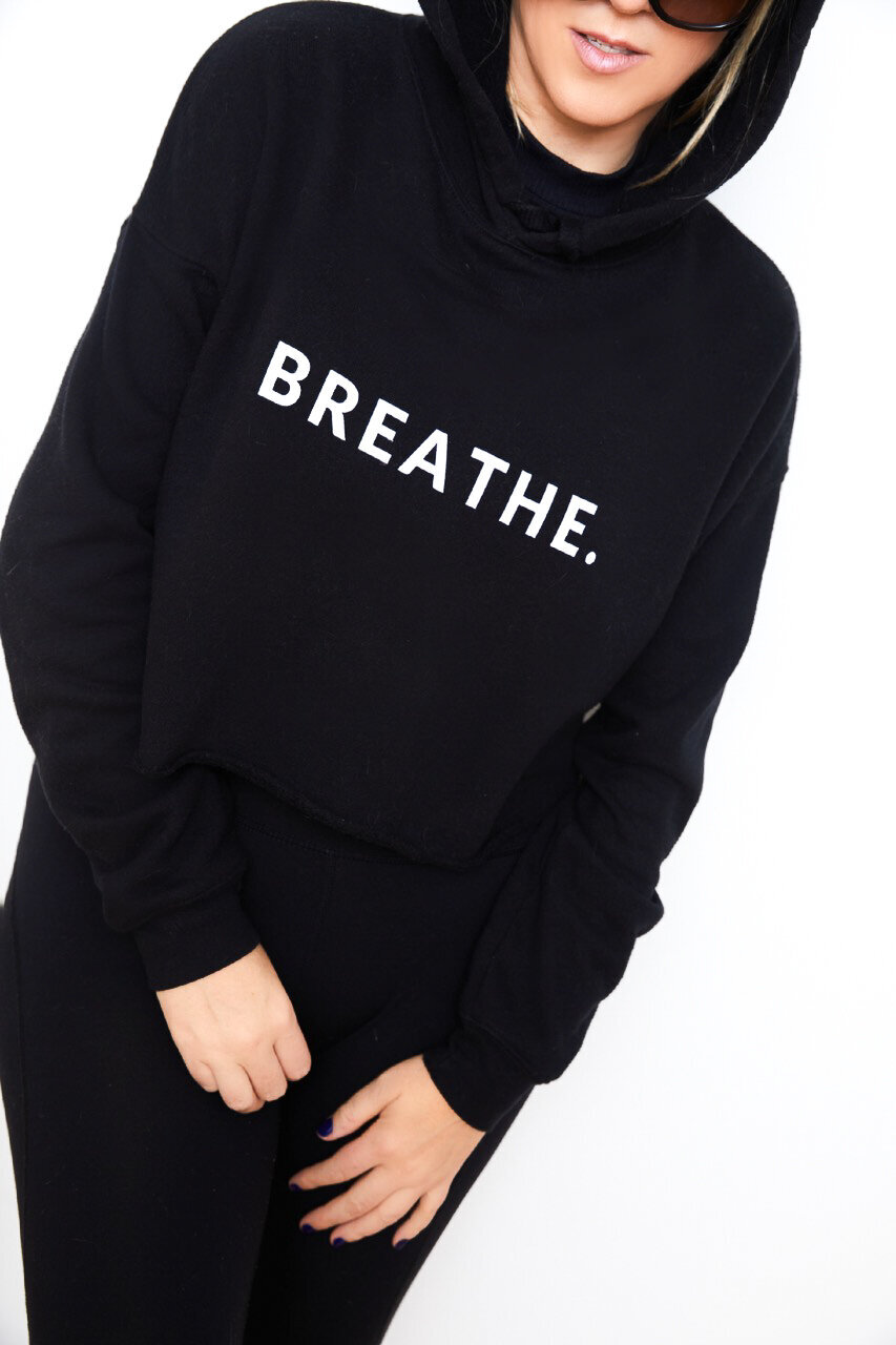 Georgiana wearing the  cropped Breathe black hoodie from Chaos & Calm lifestyle merch shoppe